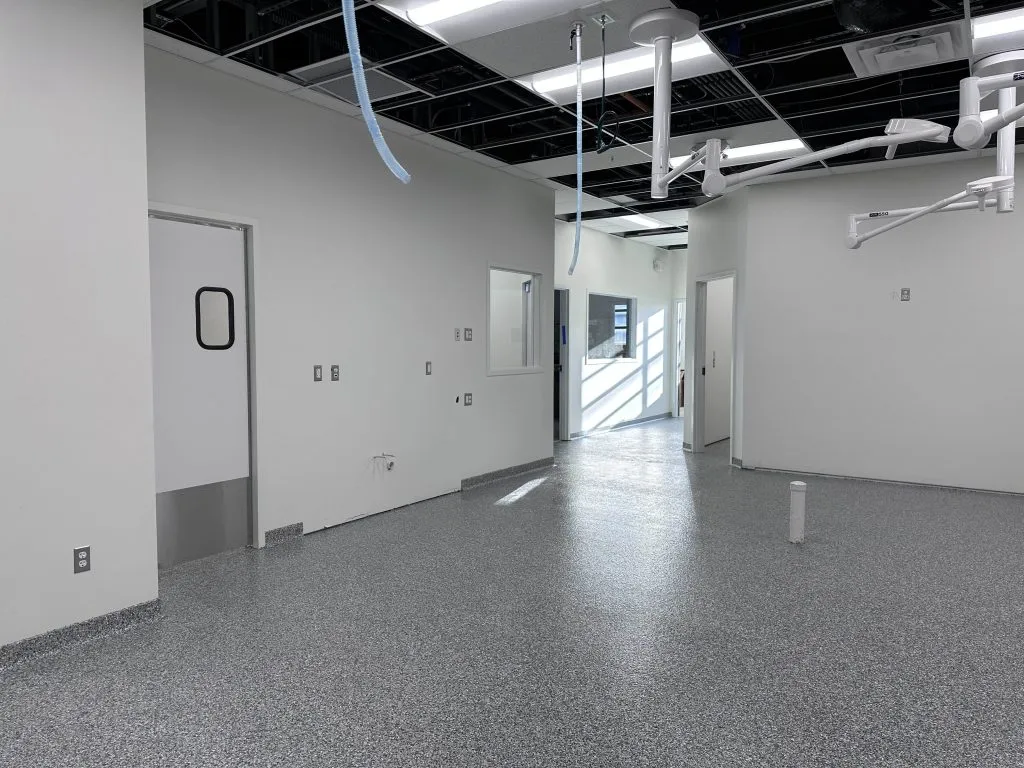 Professional installer applying epoxy flooring in a commercial space demonstrating best practices